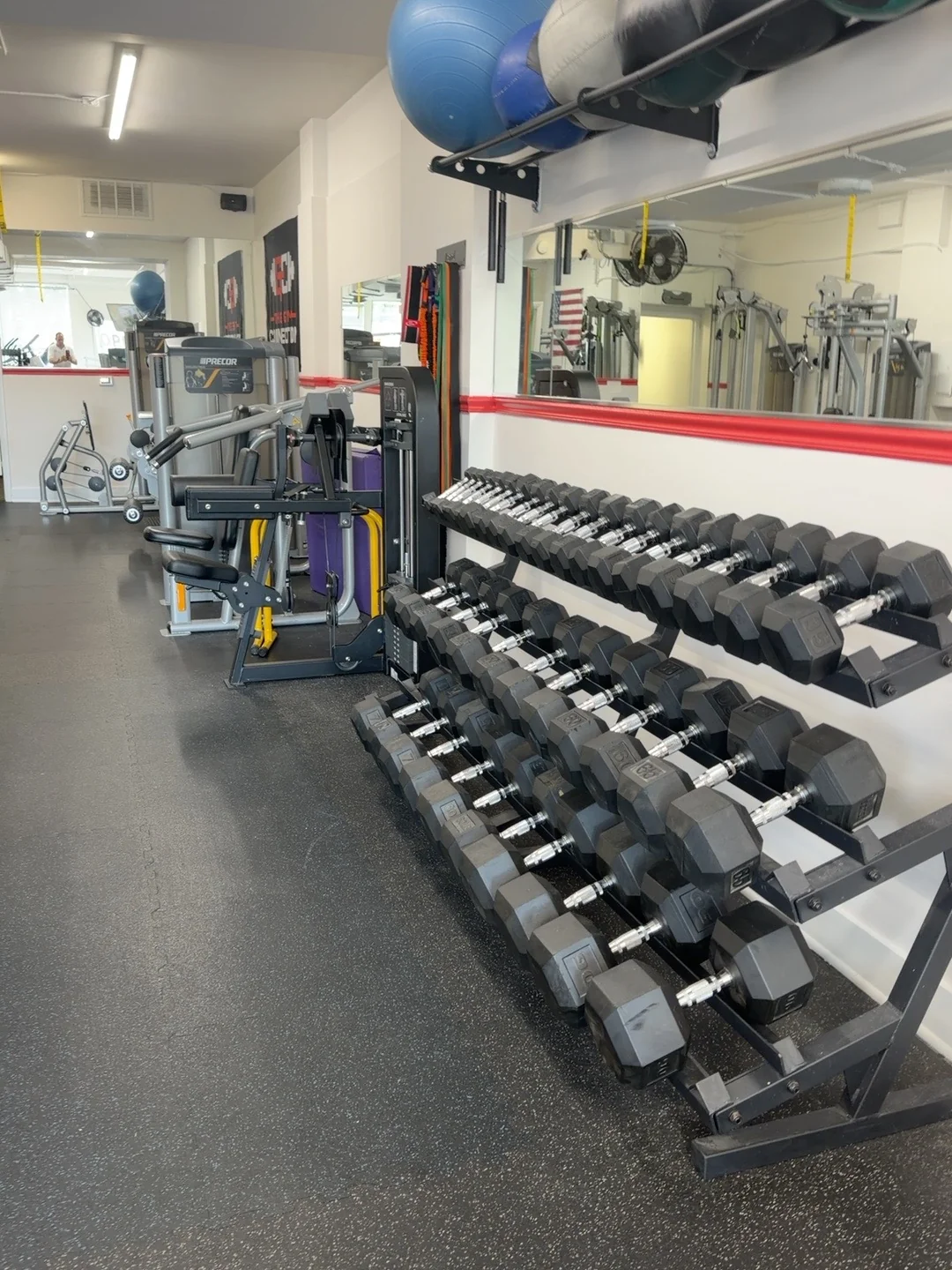 Rows of dumbbells beside the mirrored wall in The Gym Connection studio.